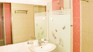 Un baño con inodoro, lavamanos y ducha.