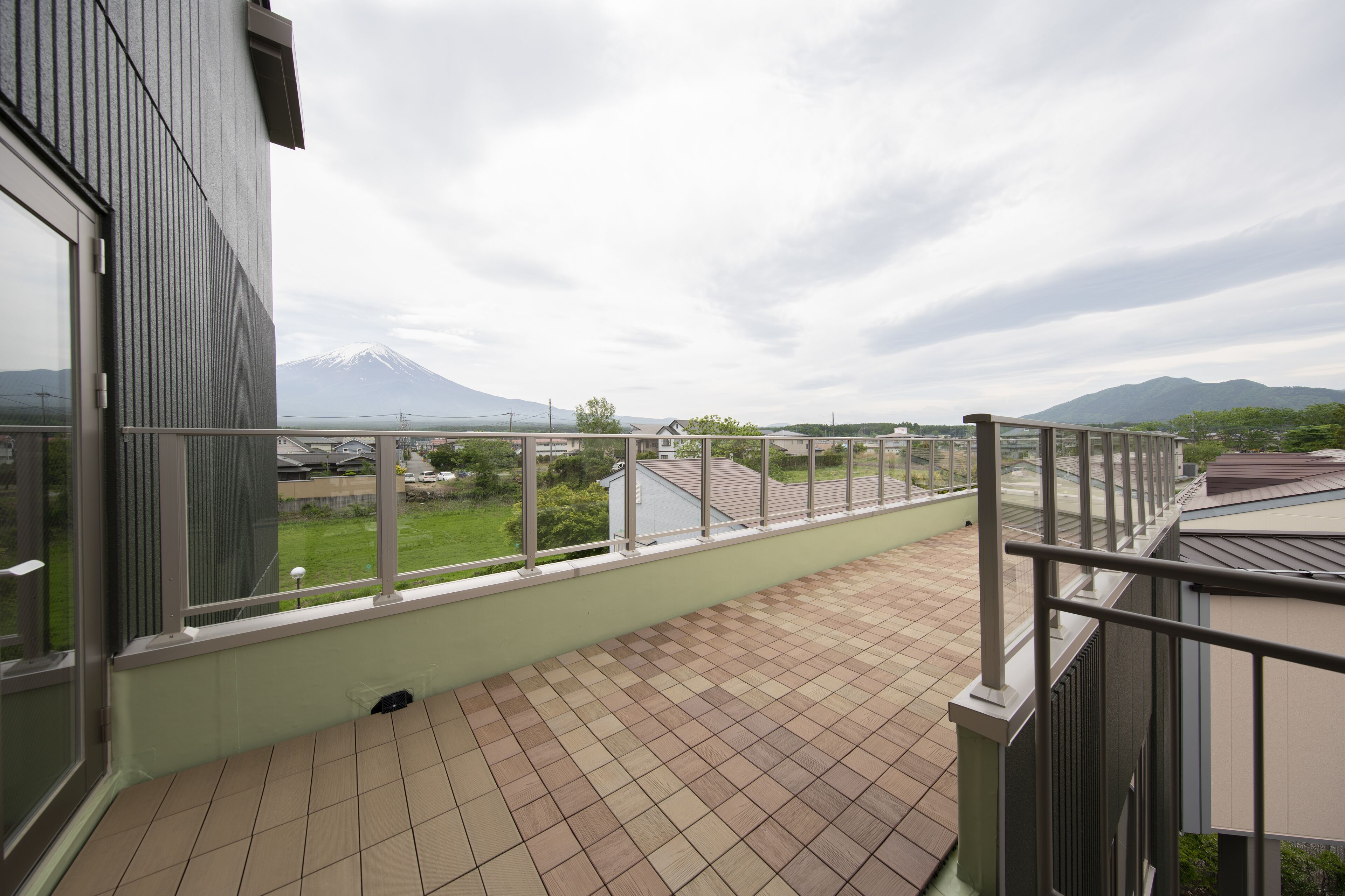 A balcony with a view of a mountain and a green landscape.