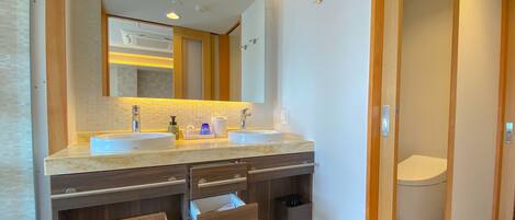 Un baño moderno con dos lavabos, un espejo grande y armarios de madera.
