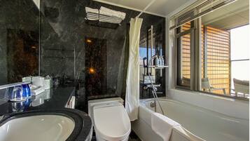 A modern bathroom with a large bathtub, a separate toilet, and a vanity with a sink.
