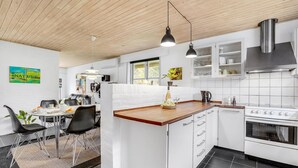 A modern kitchen with white cabinetry, a wooden countertop, and a stainless steel range hood. - Amazing home in Ulfborg with kitchen (Ulfborg)