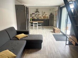 A modern living room with a grey sofa and a wooden chest of drawers. - The Pretty Little House  (Onzain)