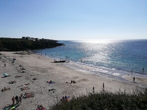 A beach with people sunbathing and swimming, a clear sky, and a rocky coastline. - Sea, space, calm and comfort, welcome to Brittany! (Le Conquet)