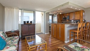 Una cocina moderna con armarios de madera, microondas y refrigerador de acero inoxidable.