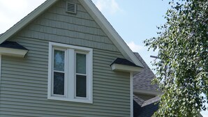 A two-story house with a porch, numbered 911, and a small garden area with red chairs. -  Beautiful Victorian Home Close to beaches-Close To Downtown/Shops/Restaurants (Traverse City)