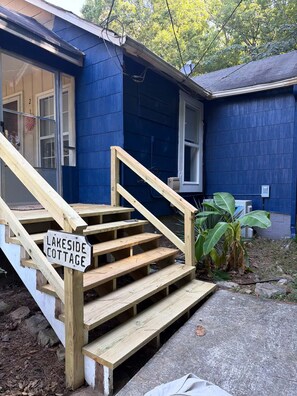 A wooden staircase leading to a blue house with a sign reading 'Lakeside Cottage.' - Lakeside Cottage - Lake, Private Hot Tub (Guild)