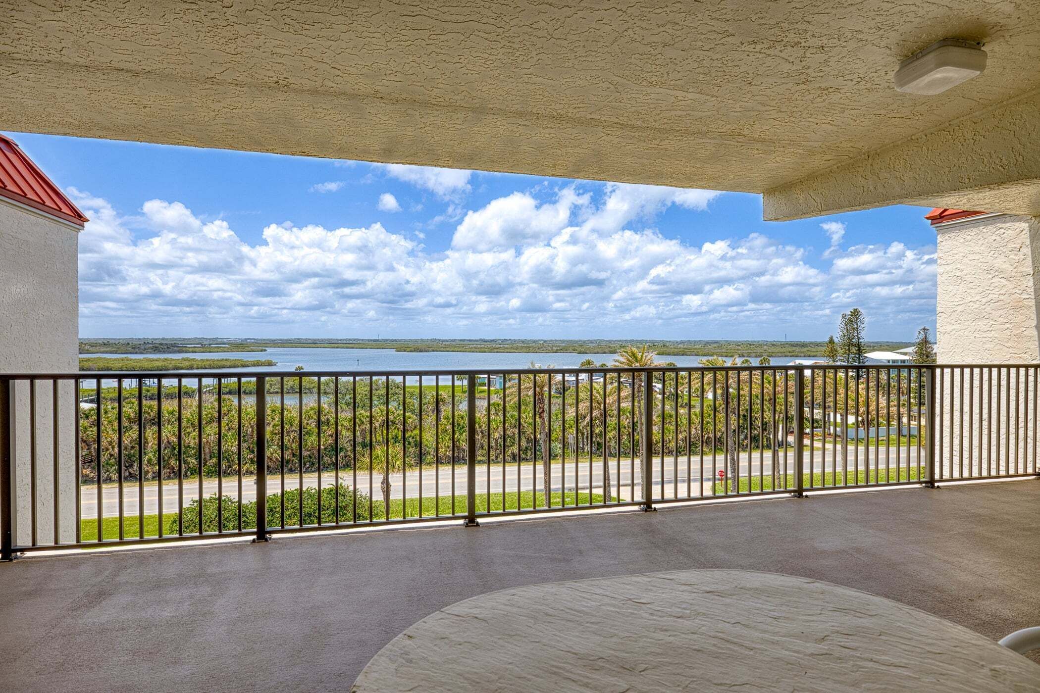 A balcony with a view of a lake and distant landscape.