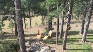 Un cadre naturel en plein air, avec un petit ruisseau, des chaises en bois et une structure en bois rustique.