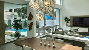A modern dining area with a wooden table, white chairs, and decorative wall art.