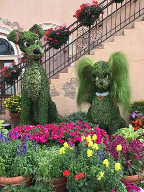 A garden with topiary sculptures of animals and colorful flowers. - Refreshing south pool and spa, Near Disney, Quiet, Clean, Private, New Villa (Kissimmee)