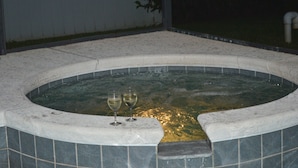 Un bain à remous avec deux verres de vin.
