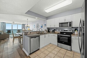 Enjoy cooking in this well-equipped kitchen with a microwave, oven, and dishwasher, and dine in the adjacent dining area with a table and chairs.