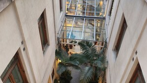 Een meerlaags atrium met glazen balustrades en een centrale binnenplaats.