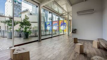 Un interior moderno con ventanas amplias, suelo de madera y vistas a los edificios exteriores.