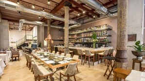 Een restaurant met lange gedeelde tafels en een bar.