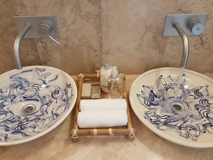 Dos lavamanos con diseños azules y blancos, un perchero y artículos de aseo.