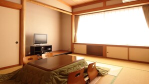 A traditional Japanese room with tatami flooring, a low table, a television on a cabinet, and a sliding door. - Tuji Wakuwaku Land Minshuku Chaya (Uozu)