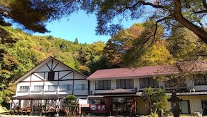 A traditional Japanese-style building with a gabled roof and a covered outdoor seating area.