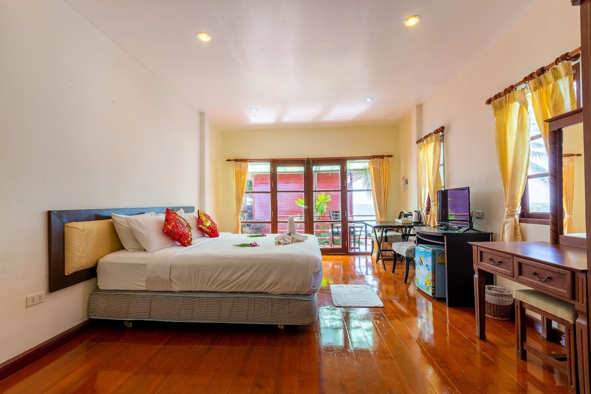 Habitación de hotel con cama, escritorio y vistas a través del ventanal.