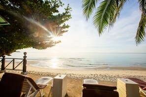 A beach view with lounge chairs and a wooden fence. - Chaweng Bliss Bungalow (Koh Samui)