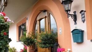 Un bâtiment à la façade jaune, avec une porte en bois et une boîte aux lettres.