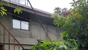 A sign reading "HIDDEN GARDEN" with a staircase leading up to a building, surrounded by lush greenery and plants. - Hidden Garden Pension (El Nido)