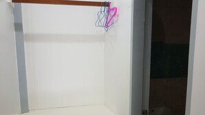 A small, enclosed bathroom with a white sink and a door leading to a darker room. - Hidden Garden Pension (El Nido)