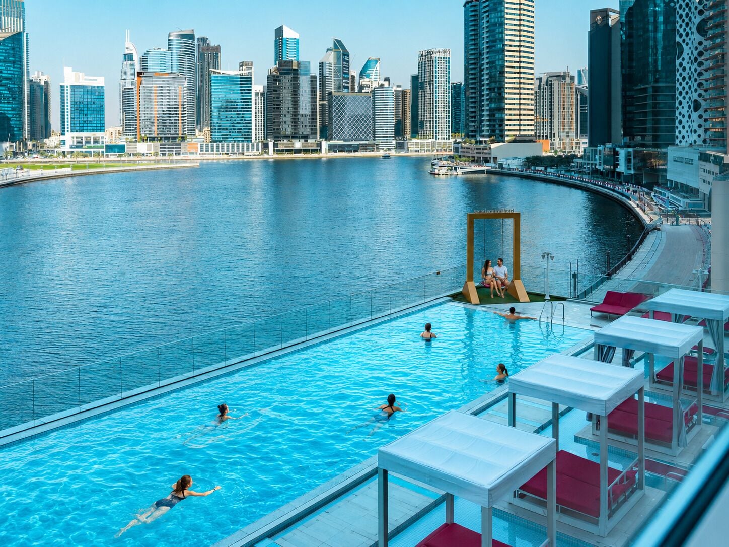 Ein Schwimmbecken mit einer Stadtlandschaft im Hintergrund.
