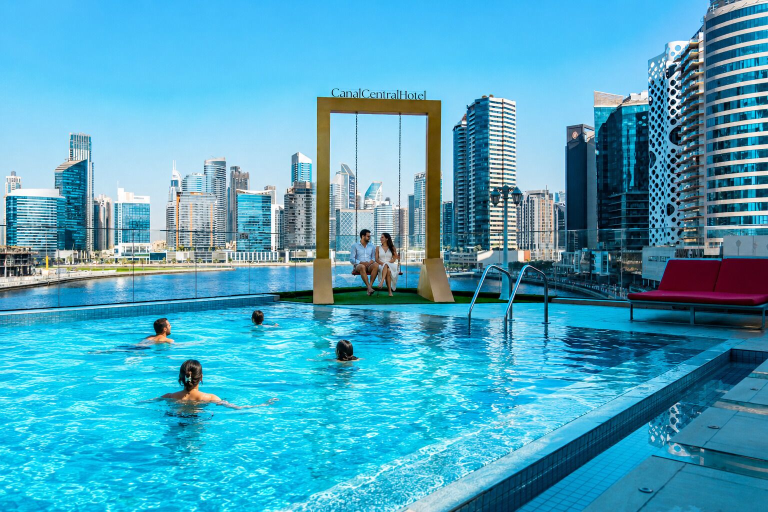 Zona de piscina con un columpio, rodeada de edificios modernos, lo que sugiere un entorno hotelero.