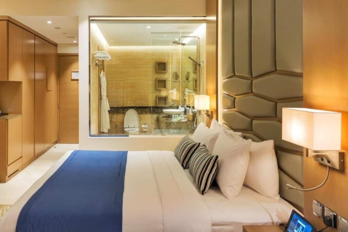 A hotel room with a large bed, a view of the bathroom, and a modern design.
