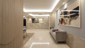 A modern hotel lobby with a reception desk, seating area, and artwork on the walls. - Yeonsan Hound Hotel (Busan)