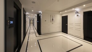 A modern hotel corridor with a polished floor, numbered doors, and a clean, minimalist design. - Yeonsan Hound Hotel (Busan)