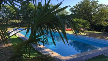 Alberca al aire libre y camastros