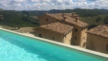 Outdoor pool, an infinity pool, pool umbrellas, pool loungers