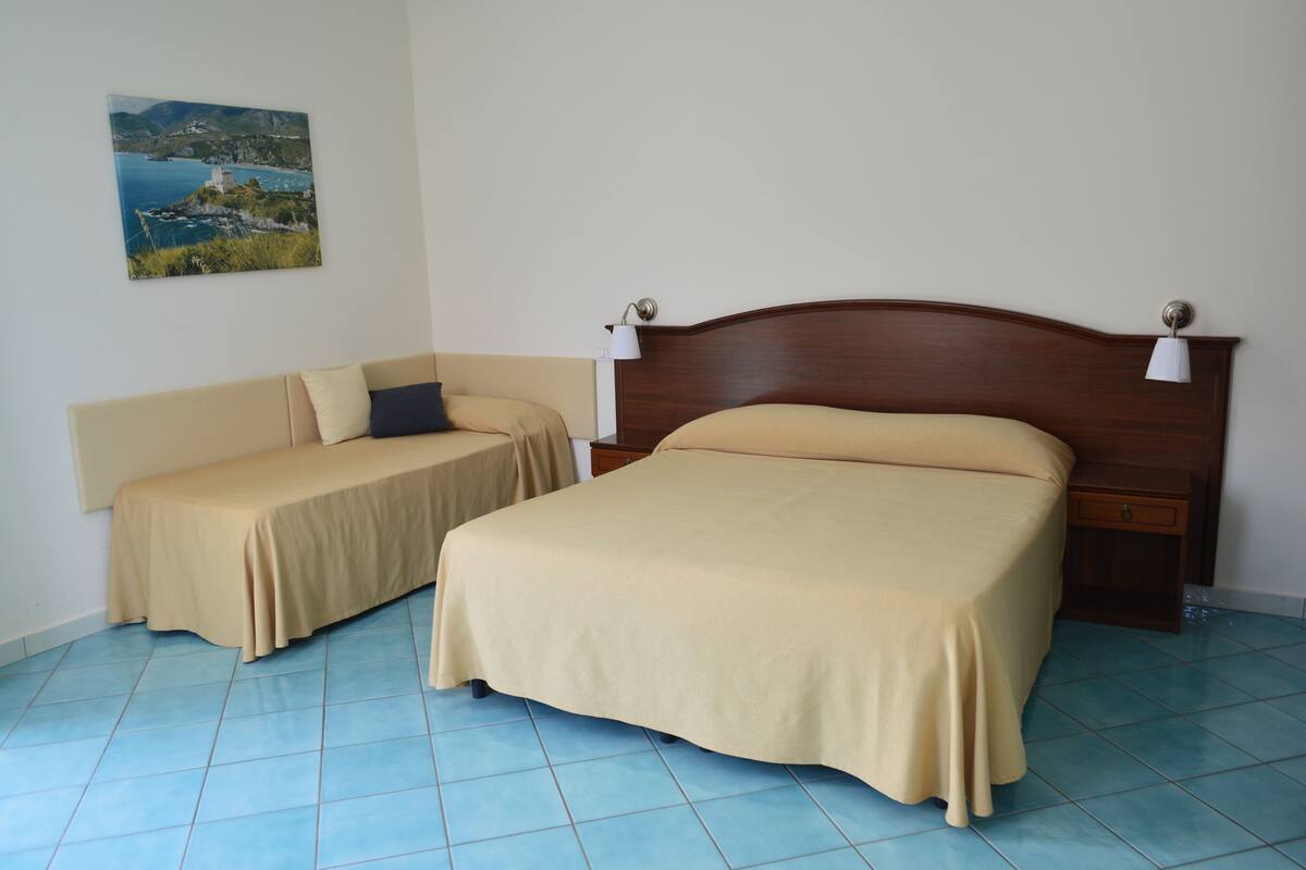 Ein Schlafzimmer mit einem Bett, einem Schlafsofa und einem Nachttisch.