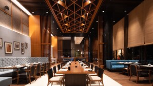 Une salle de conférence moderne, dotée d’une longue table, de chaises et d’un canapé bleu.