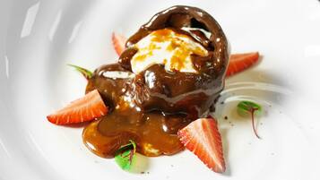 A dessert with chocolate sauce and strawberries on a white plate.