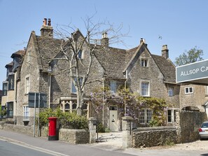 A stone building with a traditional architectural style, featuring multiple chimneys and a prominent sign reading "Allsop Castle".