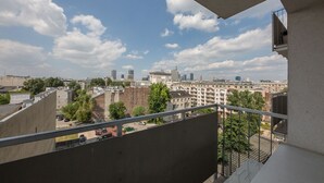 Een hoog gebouw met uitzicht op een stadsgezicht, inclusief diverse gebouwen en een heldere lucht.