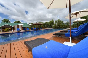 A pool area with lounge chairs and umbrellas. - Keinnara Loikaw (Loikaw)