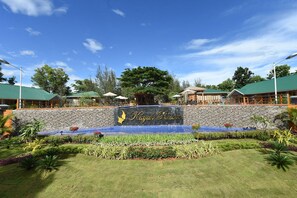 A resort with a sign reading "Kayak Resort," a stone wall, and a landscaped garden with a water feature. - Keinnara Loikaw (Loikaw)