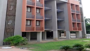 Un edificio de varios pisos con un diseño arquitectónico moderno, que cuenta con balcones y un patio central.
