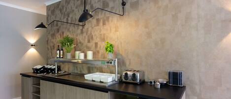 Una cocina moderna con encimera de madera, un tostador integrado y una lámpara colgante.