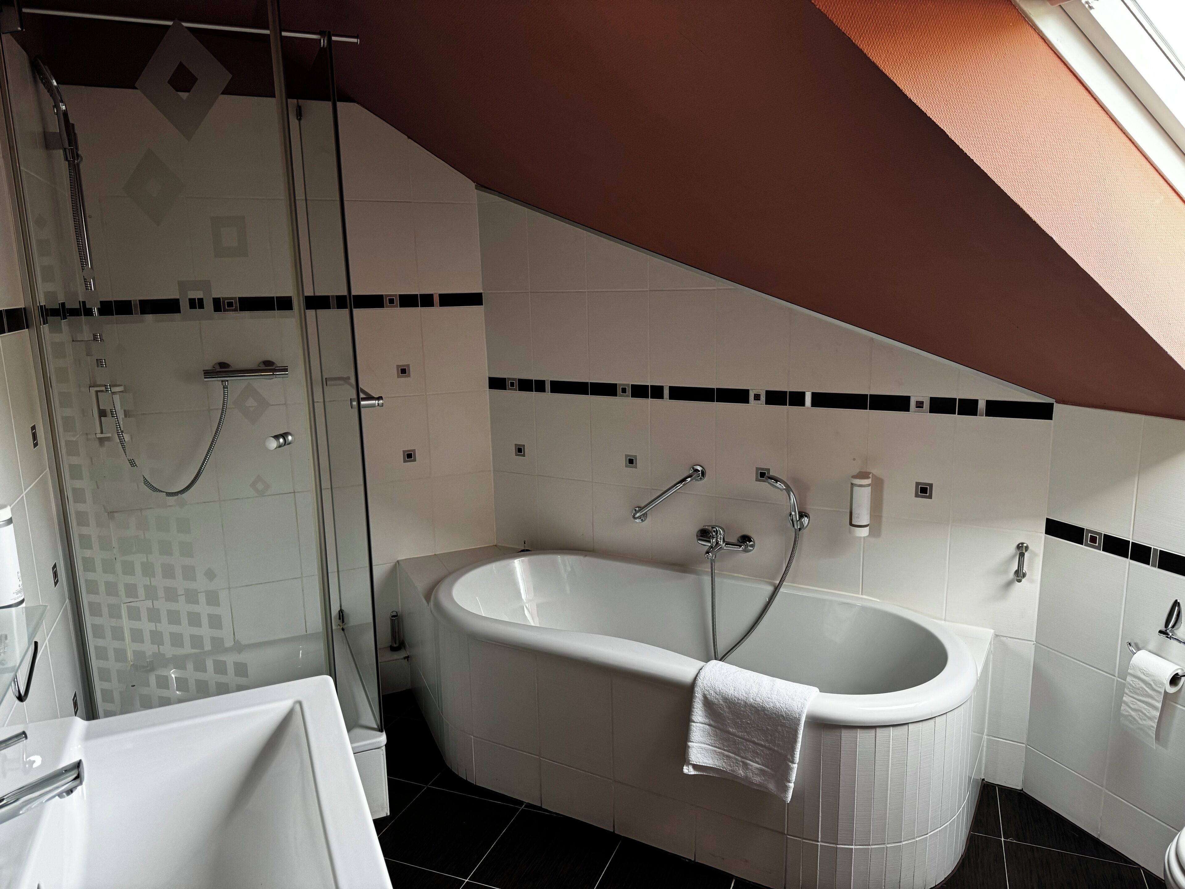 Ein modernes Badezimmer mit freistehender Badewanne, einer Duschkabine und einem gefliesten Boden.