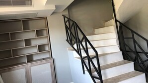 Una escalera con barandilla de metal negro y pared blanca.