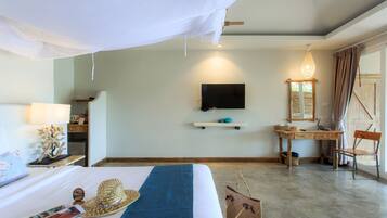 A hotel room with a bed, a desk, a TV, and a window with curtains.