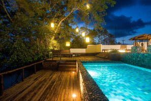 A wooden deck with a swimming pool, surrounded by trees and outdoor lighting. - Sripakpra Boutique Resort Phatthalung (Khuan Khanun)