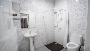 A modern bathroom with a shower, toilet, and sink. - Mr. T Kamala Room (Kamala)