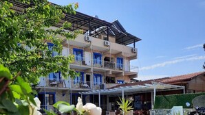 A hotel with a pool area, outdoor seating, and a covered patio.
