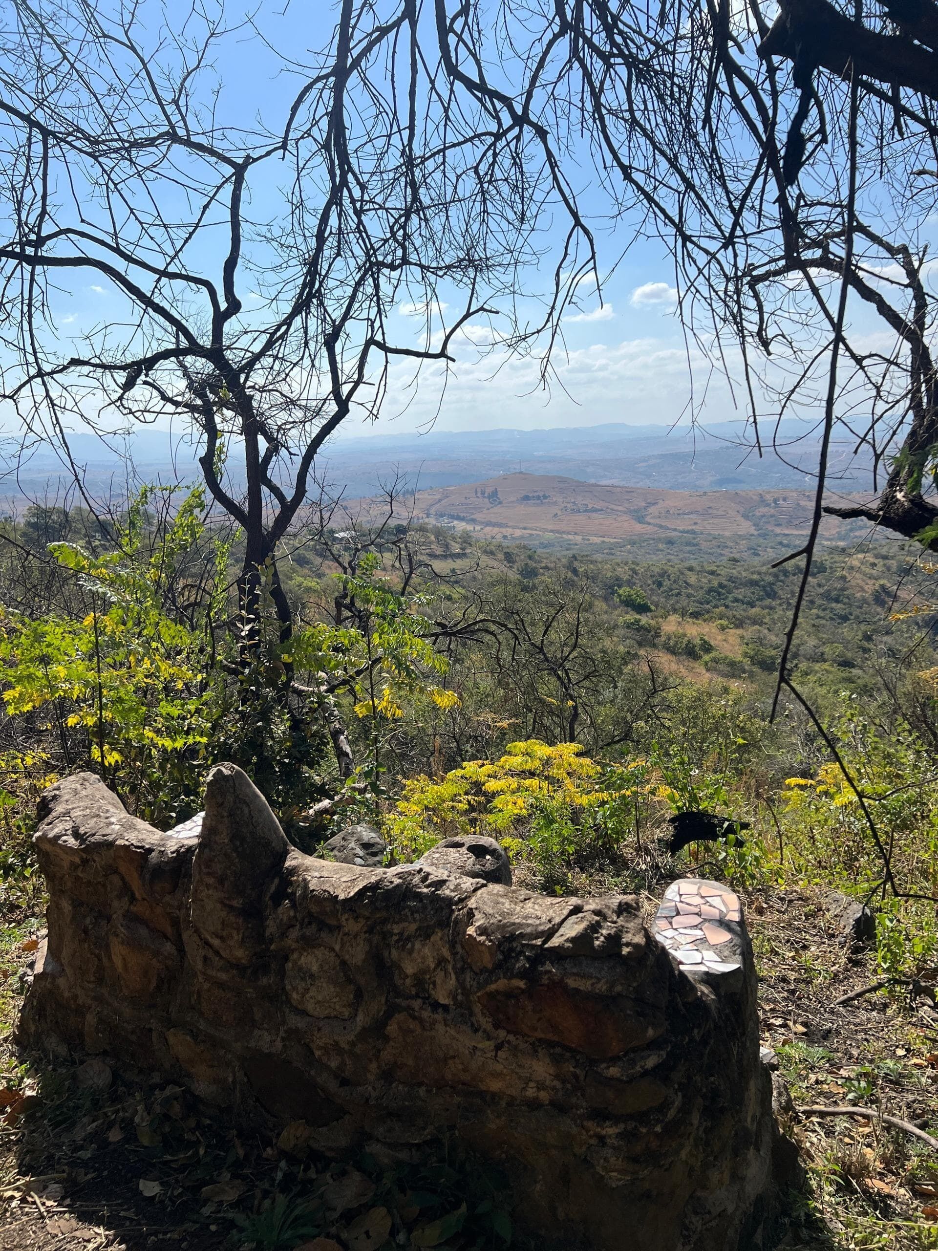 A stone structure with a view of a hilly landscape.